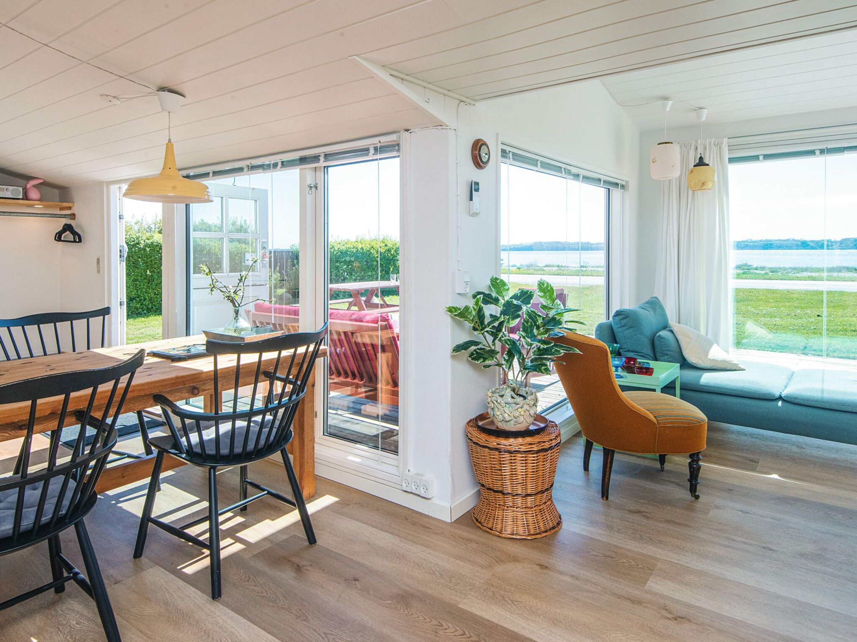Ein modernes Interieur mit Essbereich, einer Couch und Blick ins Freie.