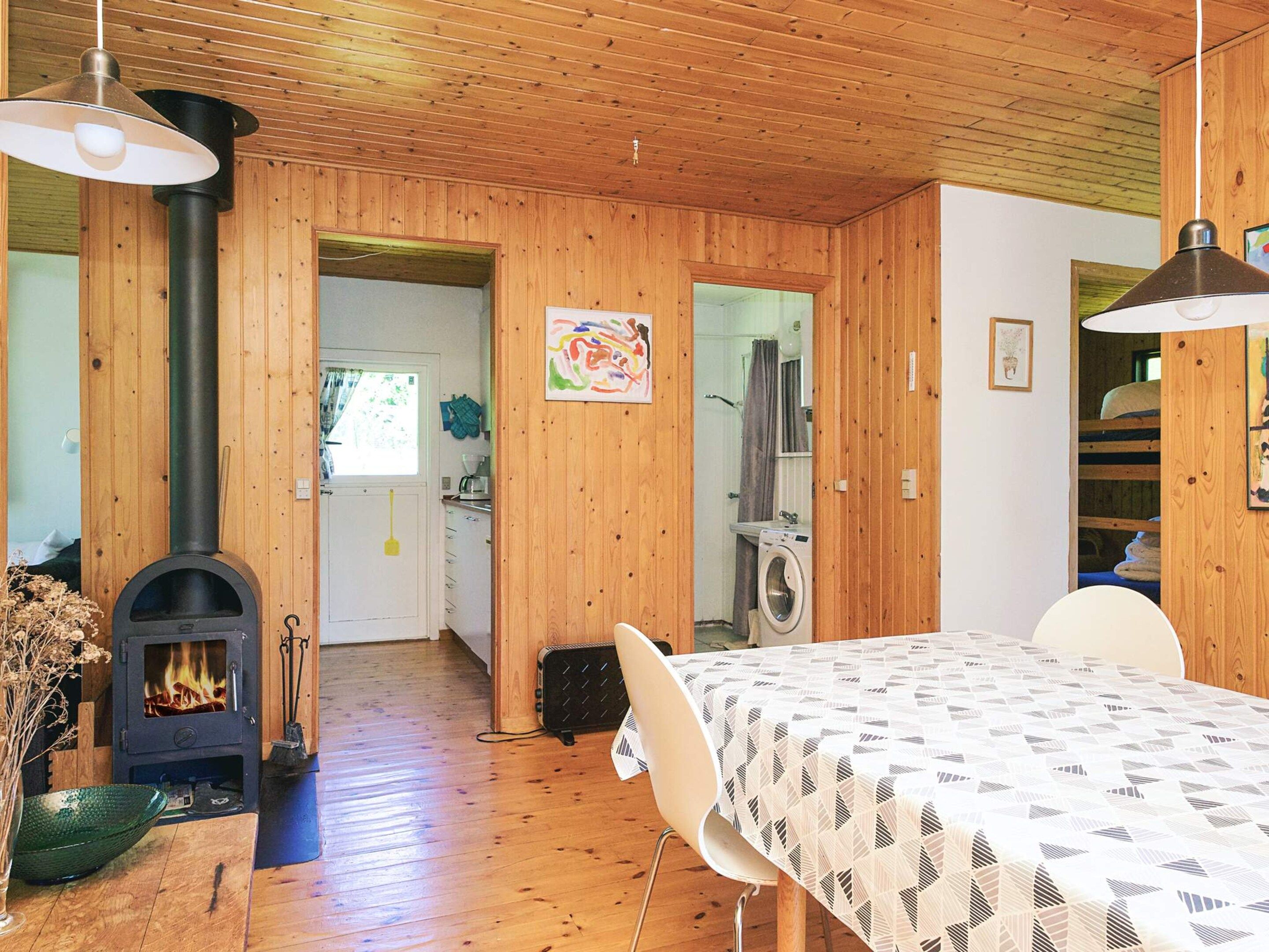 Ein Holzinnenraum mit Kamin, Waschmaschine und Essbereich.