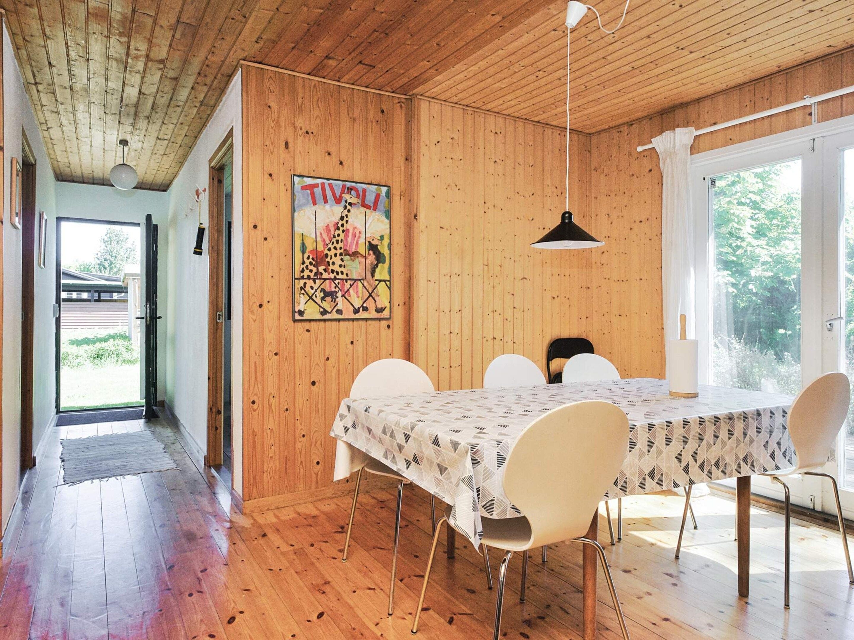 Ein Essbereich mit Holzboden, einem Tisch mit gemustertem Tischläufer und Stühlen.