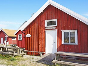 A red wooden building with a white door and windows, labeled 'MARTAS SJÖBOD' and 'Fiske Museum'.