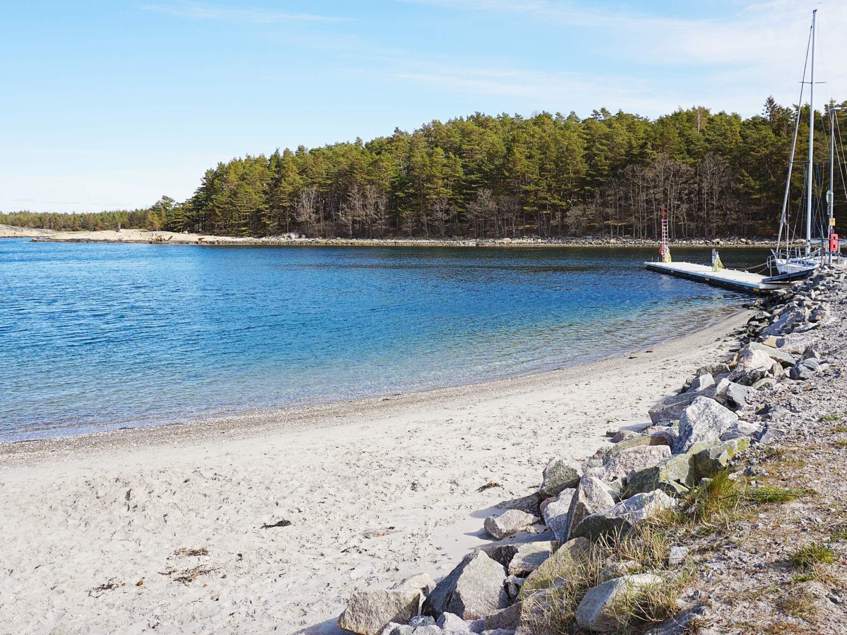 A clear lake with a rocky shoreline and a dock extending into the water.