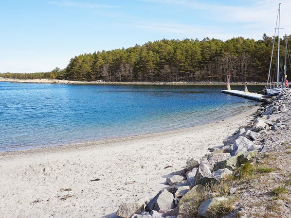 A clear lake with a rocky shoreline and a dock extending into the water.