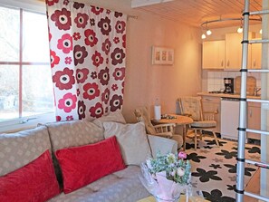 A cozy living area with a sofa, a dining table, and a kitchen in the background. - 4 Person Holiday Home in Morbylanga (Morbylanga)