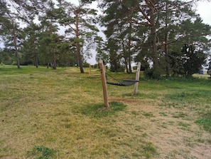 A hammock swing in a grassy park area with trees in the background. - 4 Person Holiday Home in Morbylanga (Morbylanga)