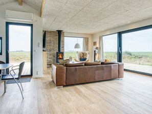 A spacious living room with a large window, a fireplace, and a view of the outdoors.