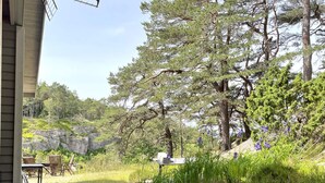 A residential property with a patio area, outdoor seating, and a natural landscape with trees and rocks. - 3 Person Holiday Home in Uddevalla (Uddevalla)