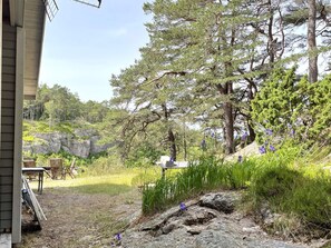 A residential property with a patio area, outdoor seating, and a natural landscape with trees and rocks. - 3 Person Holiday Home in Uddevalla (Uddevalla)