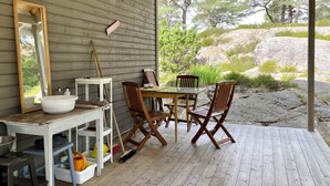 A wooden deck with a table and chairs, a sink, and a mirror. - 3 Person Holiday Home in Uddevalla (Uddevalla)