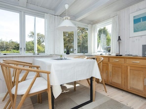A dining area with a table, chairs, and a view of the outdoors.