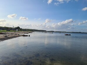 A calm lake with boats, a pier, and a distant shoreline with buildings. - 6 Person Holiday Home in Sjolund (Sjølund)