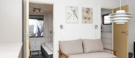 A modern living room with a sofa, a coffee table, and artwork on the wall.