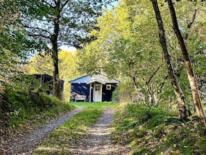 A rustic cabin with a wooden exterior, a porch, and a gravel path leading to it. - 4 Person Holiday Home in Aars (Aars)