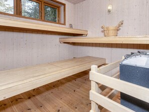 A wooden sauna room with benches and a wooden bucket. - 4 Person Holiday Home in Aars (Aars)