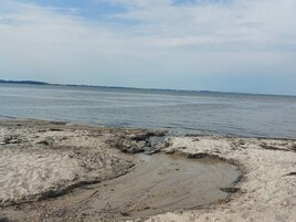 Una playa con costa rocosa y agua tranquila.