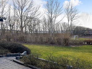 A paved pathway leading to a grassy area with a soccer goal, surrounded by leafless trees and a clear sky. - 6 Person Holiday Home in Farso (Farso)