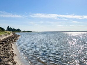 A beach with a clear sky and calm water. - 6 Person Holiday Home in Farso (Farso)