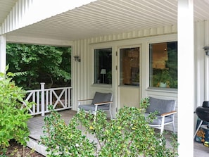 A covered porch with two chairs and a grill. - 4 Star Holiday Home in Lyckeby (Lyckeby)