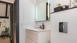 A modern bathroom with a white vanity, a glass shower enclosure, and a wall-mounted toilet. - 4 Person Holiday Home in Hejls (Hejls)