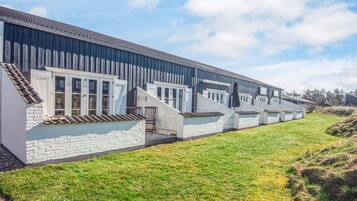 En række moderne, etetages bygninger med store vinduer og et fladt tag, sandsynligvis et hotel eller et boligkompleks.