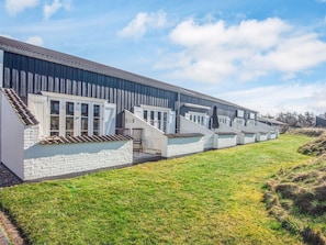A row of modern, single-story buildings with large windows and a flat roof, likely a hotel or residential complex.