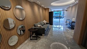 A modern lobby with a sofa, round mirrors, and a coffee table.