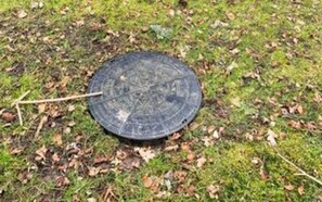 A circular object on the ground with a stick nearby.