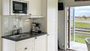 A compact kitchen with a microwave, coffee maker, and a sink. - 3 Person Holiday Home in Lottorp (Löttorp)