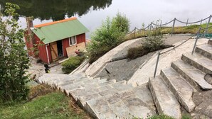 A stone staircase leading to a wooden cabin by a lake. - 8 Person Holiday Home in Sveio-by Traum (Sveio)