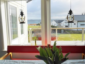 A room with a window overlooking a residential area, a red bench, and a potted plant. - 4 Star Holiday Home in Hoviksnas (Höviksnäs)