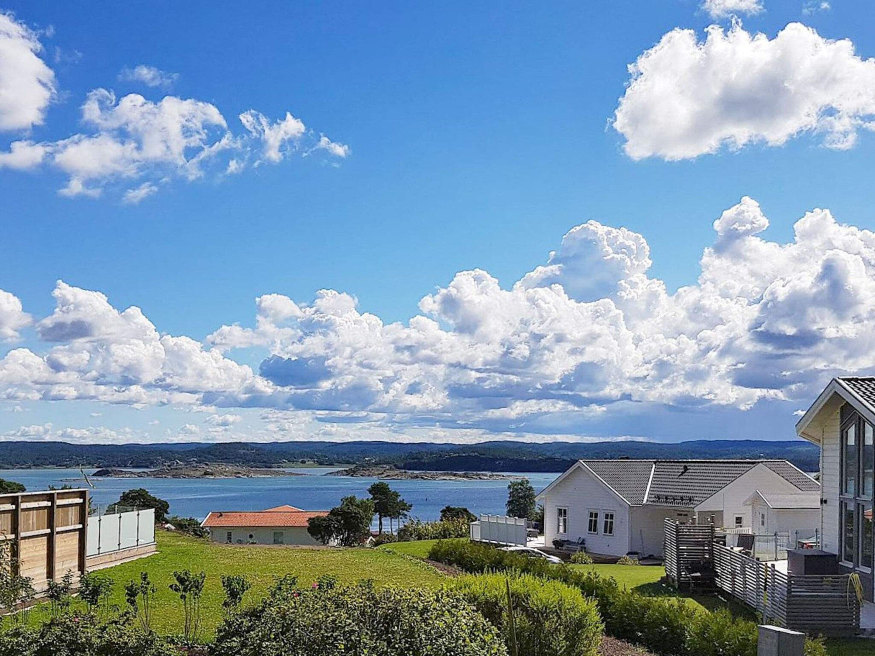 Une propriété située sur la côte, offrant une vue sur la mer, avec des bâtiments blancs et un ciel dégagé.