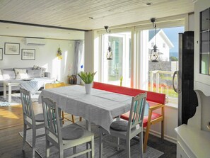 A dining area with a table set for four, surrounded by chairs, and a bench with red cushions. - 4 Star Holiday Home in Hoviksnas (Höviksnäs)