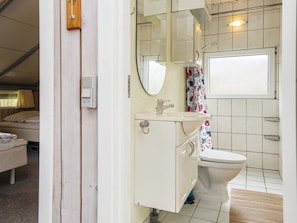 Une petite salle de bain comprenant des toilettes, un lavabo et un miroir.