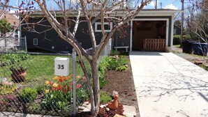 Una propiedad residencial con jardín cercado, buzón y entrada de vehículos que conduce a un garaje.