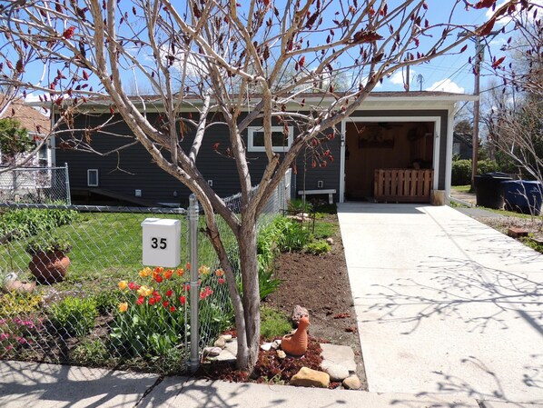 Il s’agit d’une propriété résidentielle dotée d’un jardin clôturé, d’une boîte aux lettres et d’une allée menant à un garage.