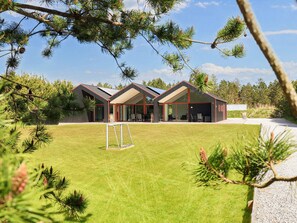 A modern house with a large lawn, a soccer goal, and a covered outdoor seating area. - 10 Person Holiday Home in Jerup (Jerup)