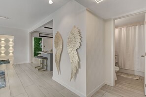 Experience the serene ambiance of this stylish space, featuring a decorative wall piece and a well-appointed kitchenette.