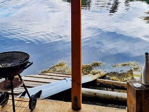 A wooden dock extending over calm water, a grill, and a bottle of wine on the dock. - 6 Person Holiday Home in Halsanaustan (Heim)