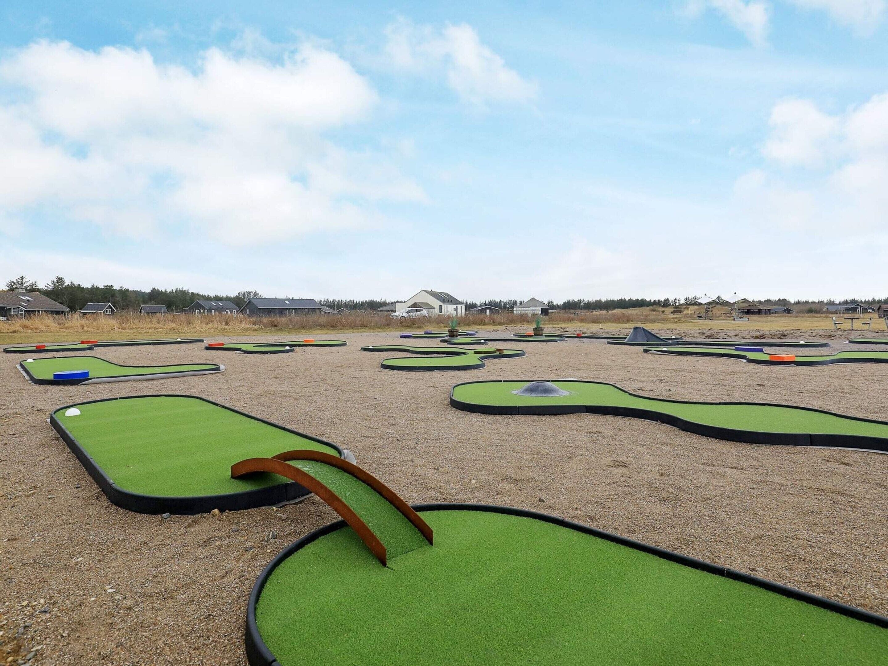 A miniature golf course with multiple green putting areas and a few obstacles.