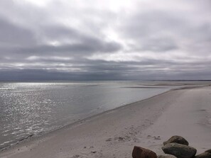 A beach with a calm sea, overcast sky, and scattered rocks. - 4 Star Holiday Home in Asaa (Asaa)