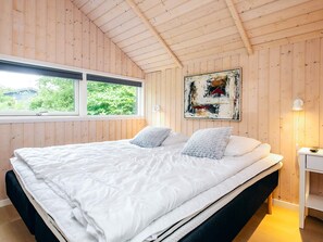 A bedroom with a large bed, a window, and a painting on the wall. - 4 Star Holiday Home in Asaa (Asaa)
