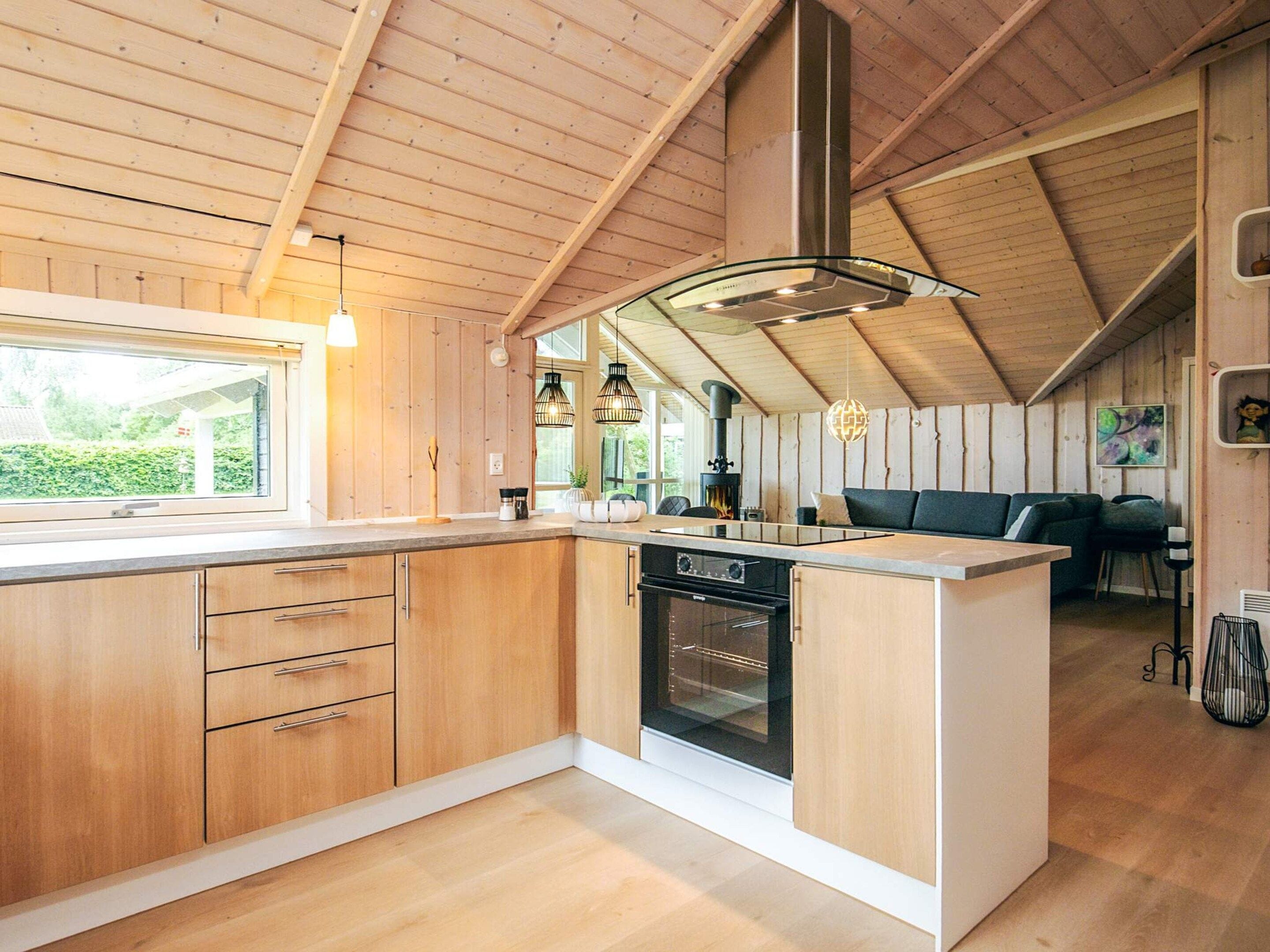 Una cocina moderna con gabinetes de madera, una isla central y un horno empotrado.