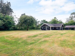 A house with a large lawn, a covered porch, and a garage. - 4 Star Holiday Home in Asaa (Asaa)
