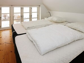 A bedroom with a bed, pillows, and a window with a view of the outdoors. - 14 Person Holiday Home in Havndal (Havndal)