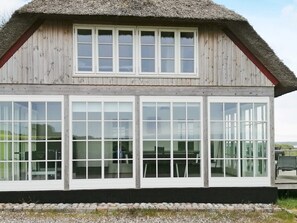 A wooden building with a thatched roof and large windows. - 14 Person Holiday Home in Havndal (Havndal)