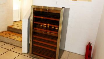 A stainless steel oven with a glass door, located in a kitchen area with tiled flooring and a white wall.