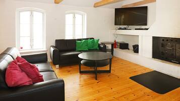 Una sala de estar amoblada con sofá, mesa de centro y chimenea.