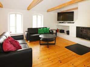 A furnished living room with a sofa, a coffee table, and a fireplace.