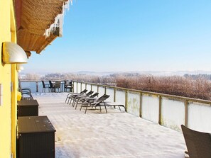 Un balcon avec des fauteuils de jardin et une vue sur un paysage enneigé.