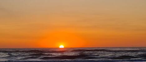A sunset over the ocean with waves.