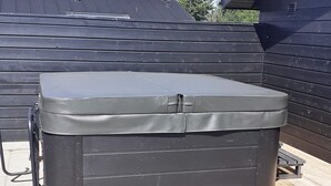 A large, dark-colored outdoor storage unit with a lid, positioned on a paved surface with a wooden deck in the background. - 8 Person Holiday Home in Hadsund (Hadsund)